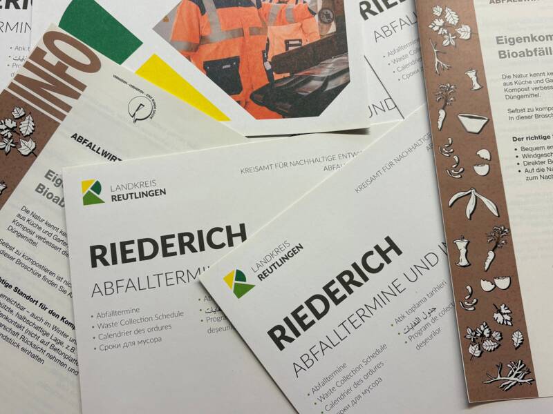 Eine Sammlung von Informationsbroschüren über Abfalltermine und Eigenkompostierung aus dem Landkreis Reutlingen liegt gestapelt auf einem Tisch.